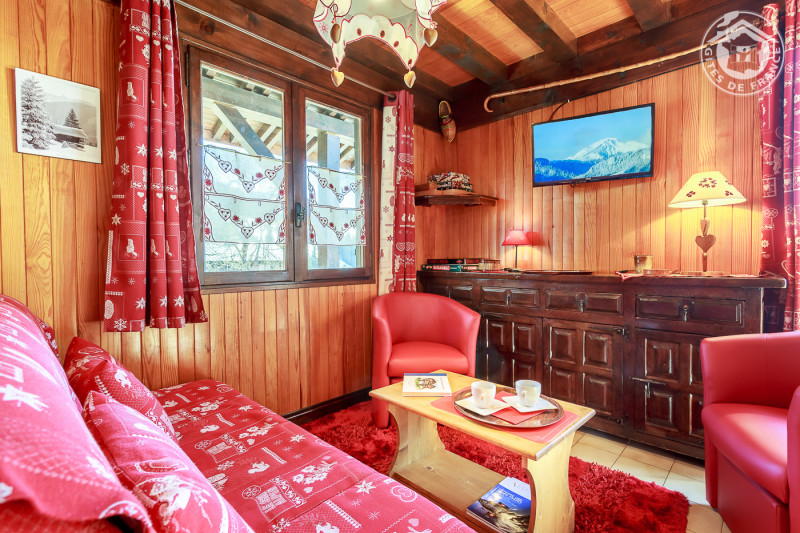 Espace salon avec banquette, 2 fauteuils, table basse et télévision murale